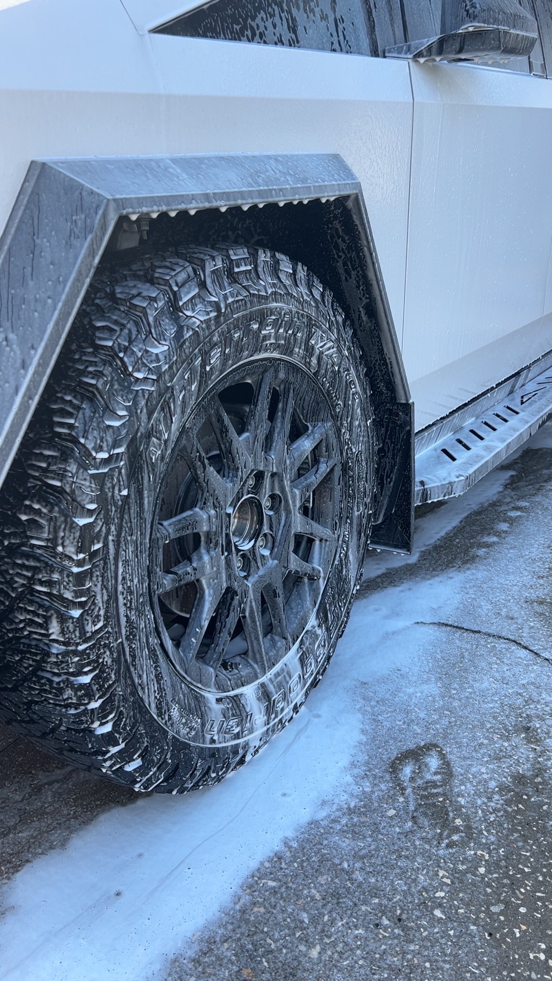 Truck wheel covered in foaming cleaner during a wash